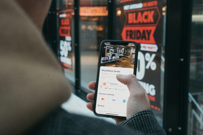 Osoba przeglądająca promocje Black Friday na smartfonie